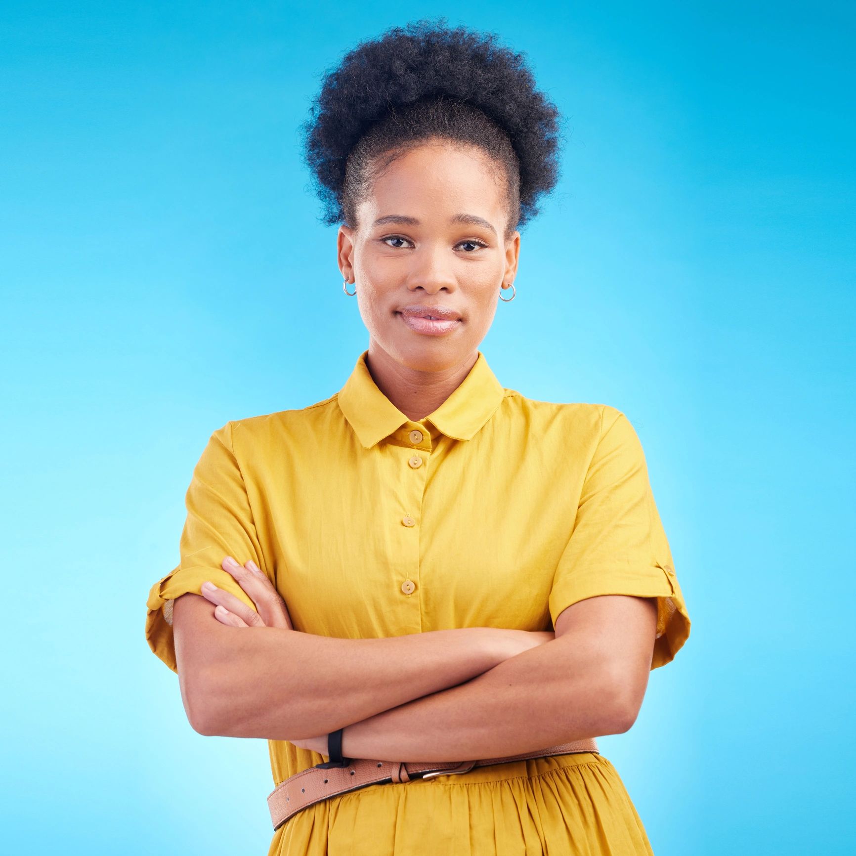 Portrait of a smiling person with arms crossed on a blue background