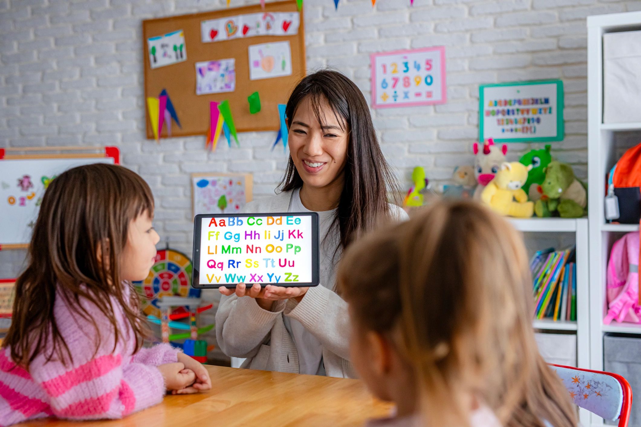 Teacher leading an interactive alphabet lesson with preschool children